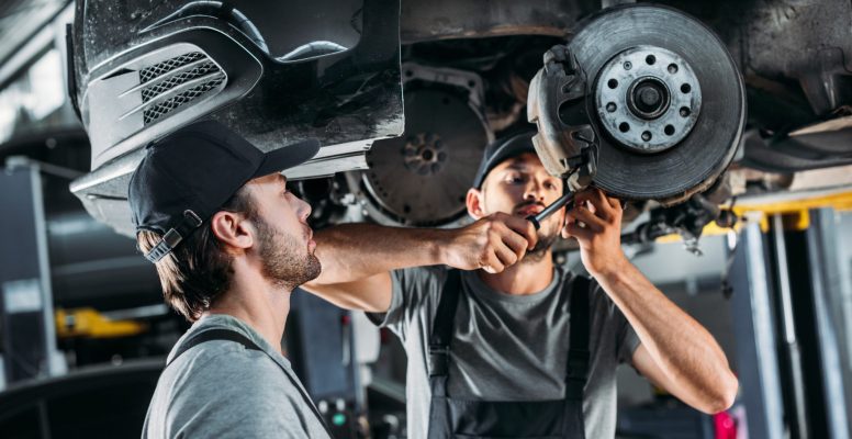 Professional mechanics repairing brakes.