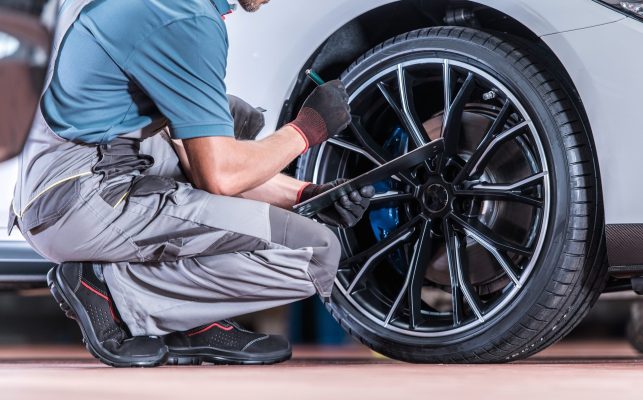 A mechanic performs checks on a tire.
