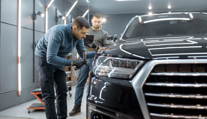 Merchanics look over a car.