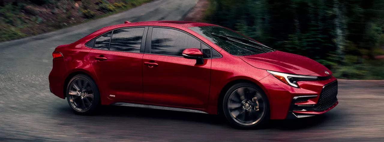 2026 Toyota Corolla driving on a road surrounded by trees