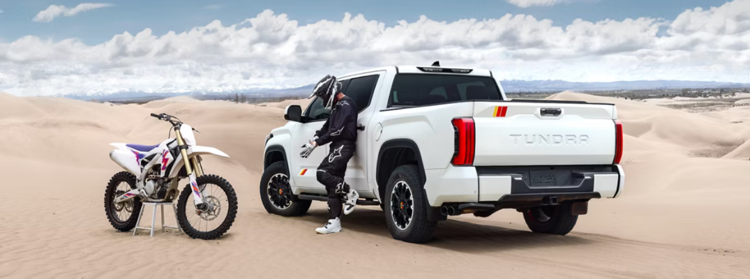 2026 Toyota Tundra parked next to a motorcycle on a sand dune