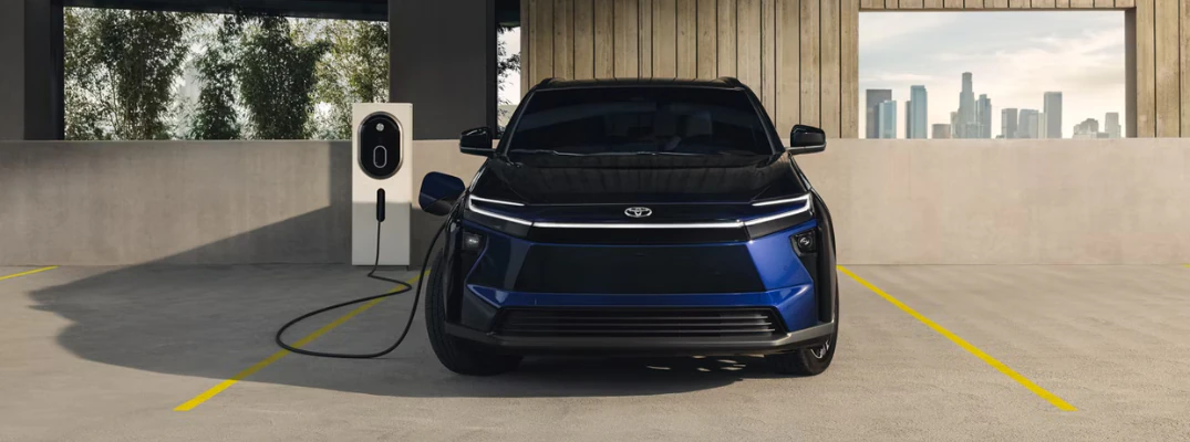 2026 Toyota bZ plugged into a charger in a parking lot