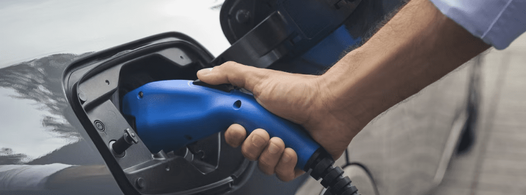 Man charging a 2026 Toyota Prius Plug-in Hybrid